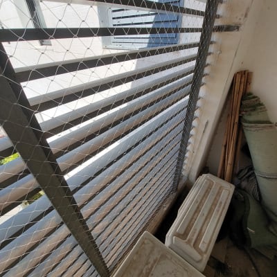 רשת מתכת מותקנת על חלון למניעת כניסת יונים