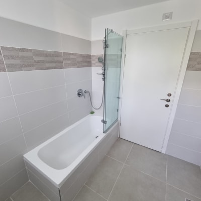 אמבטיה עם דלת זכוכית ומקלחת יד