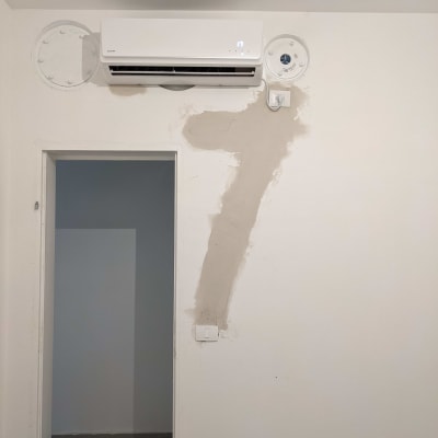 מזגן מותקן על קיר עם חיווט חשמלי גלוי