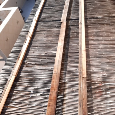 קרשים מונחים על גג עשוי במבוק