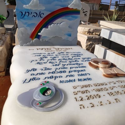 מצבה עם קשת בענן ועננים, טקסט בעברית