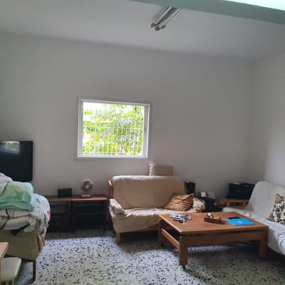 חדר מגורים עם ספות ושולחן עץ