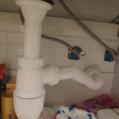 צנרת פלסטיק לבנה מתחת לכיור עם חיבורים