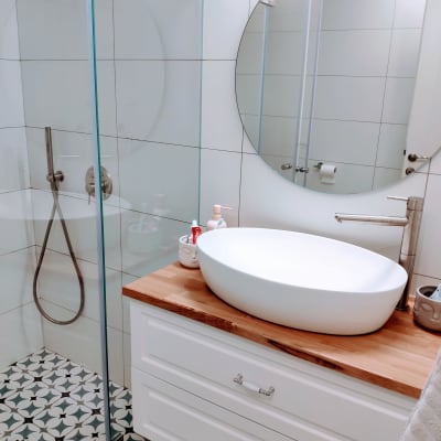 כיור עגול על משטח עץ בחדר אמבטיה משופץ