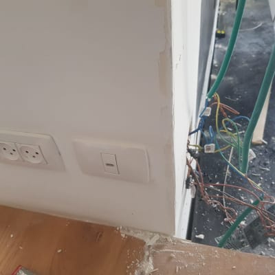 קיר עם שקעי חשמל וחוטים חשופים