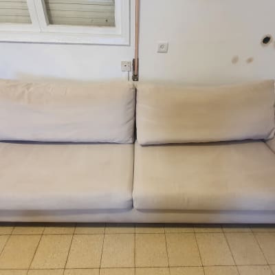 ספה בהירה עם כריות ישיבה ומשענות