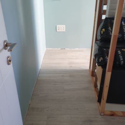 רצפת עץ חדשה, קיר צבוע, מדף עם חומרים