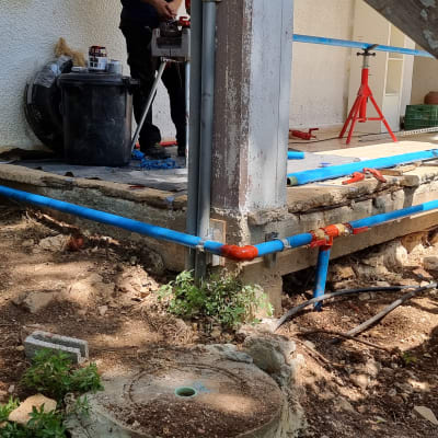 עבודת אינסטלציה עם צינורות כחולים ואדומים