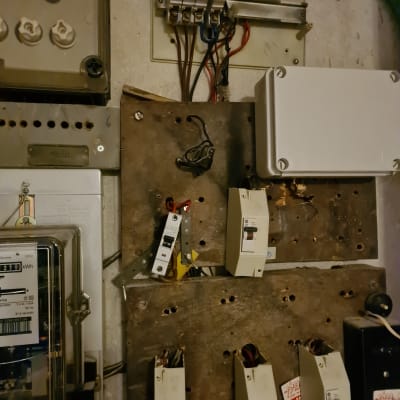 לוח חשמל עם מפסקים וחוטי חשמל חשופים
