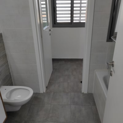 חדר אמבטיה עם אסלה, אמבטיה ורצפה נקייה