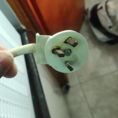 תקע חשמלי עם שלושה פינים מוחזק ביד