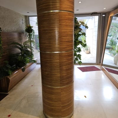 עמוד עץ מעוצב בלובי עם צמחייה מסביב