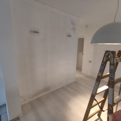 סולם עץ ליד קיר צבוע חלקית