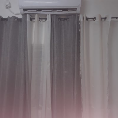 וילונות תלויים על מוט מתכת מתחת למזגן