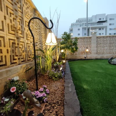 ערוגת פרחים עם תאורת גן ודשא ירוק