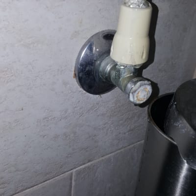 צינור מים מחובר לברז קיר עם חלודה