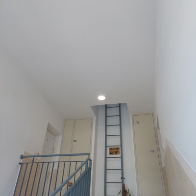 קיר צבוע בלבן עם סולם מתכת צמוד