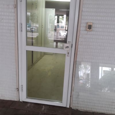 דלת זכוכית עם מסגרת לבנה ומנעול