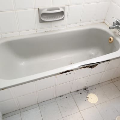 אמבטיה עם חיפוי פגום וכתמים על הרצפה