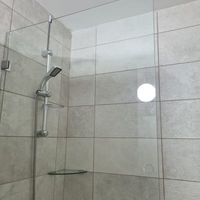 מקלחת עם ראש מקלחת וזכוכית שקופה