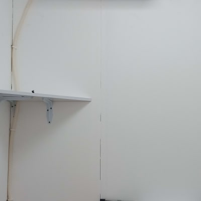 מזגן מותקן על קיר עם צינור חיבור לבן