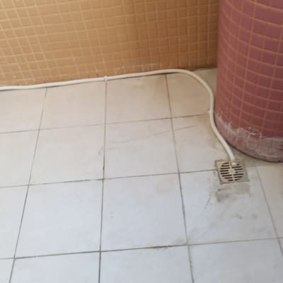 צינור לבן מחובר לרצפה ליד ניקוז