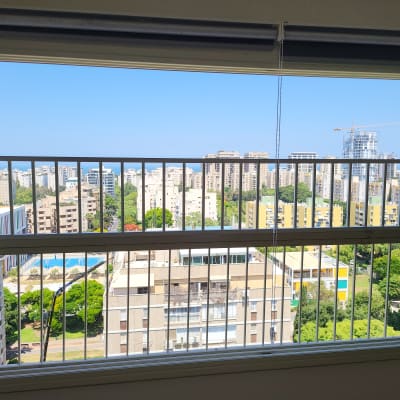 חלון עם מסגרת מתכת נוף עירוני ברקע