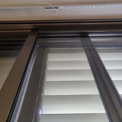 תריסים לבנים עם מסגרת מתכת כהה