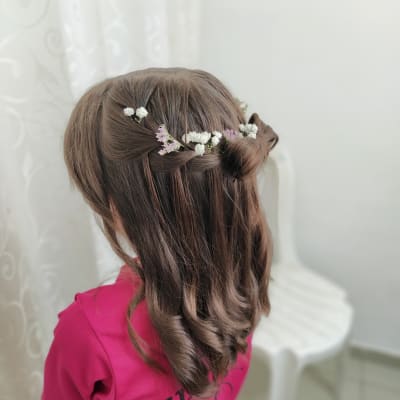 שיער גלי עם פרחים לבנים וסגולים קלועים