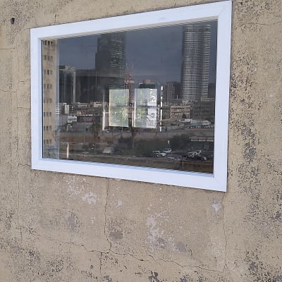 חלון עם מסגרת אלומיניום בקיר בטון