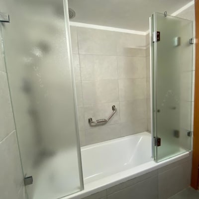 אמבטיה עם דלתות זכוכית חלבית ומוט אחיזה