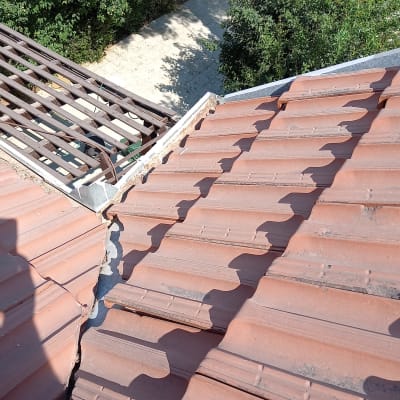 רעפים חומים על גג עם חיבור מתכת בפינה