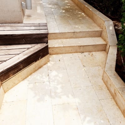 אדם מנקה שביל אבן עם מטאטא ודלי