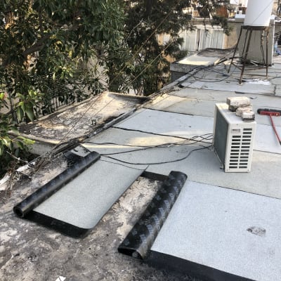 יריעות איטום על גג עם מזגן ומטאטא