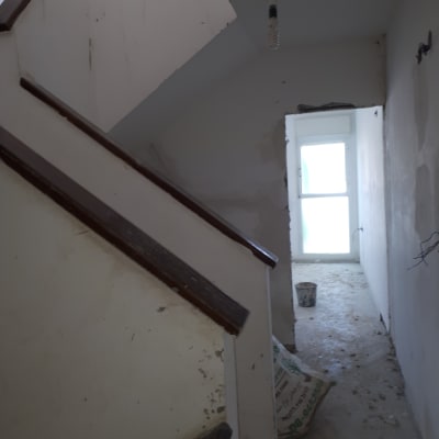 קירות צבועים בלבן עם סימני תיקון וכתמי צבע