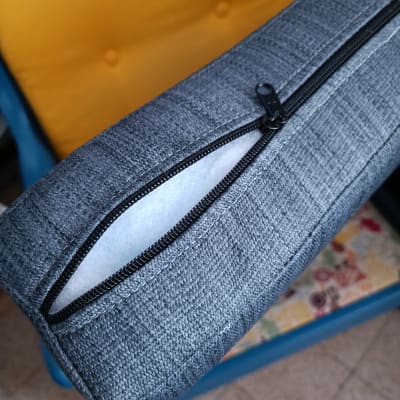 רוכסן פתוח בכרית אפורה עם ריפוד לבן