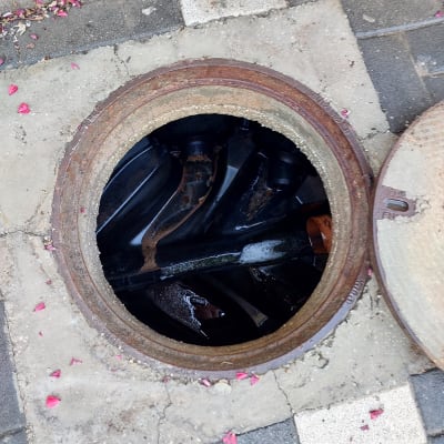 פתח ביוב עם מכסה פתוח וצינורות פנימיים