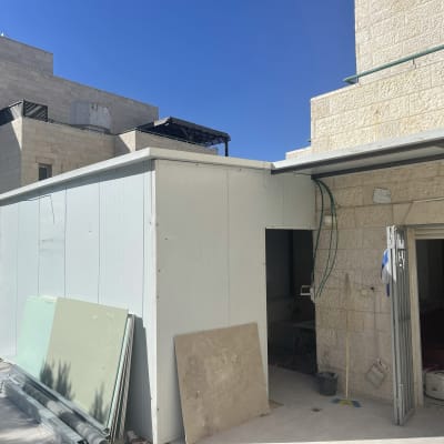 מבנה זמני עם לוחות גבס וכלי עבודה בחוץ