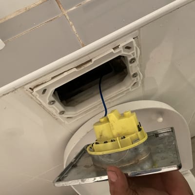 חלק צהוב של מנגנון הדחה מונח על מכסה מתכת