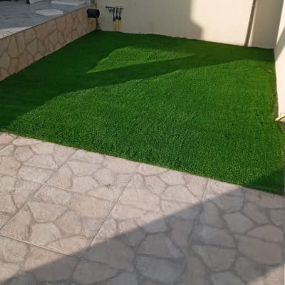 דשא סינתטי ירוק על משטח מרוצף