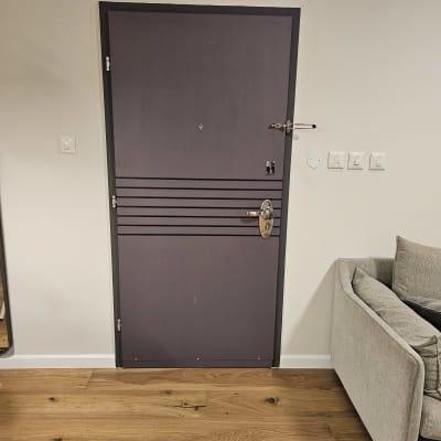 דלת מתכת עם מנעול ובריחים, על רקע קיר לבן