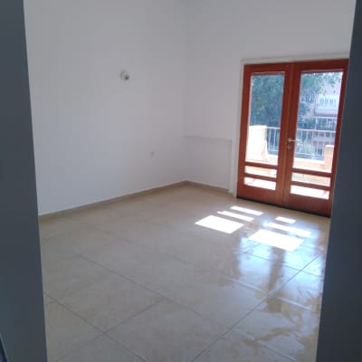 חדר ריק עם קירות לבנים ודלתות עץ