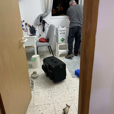 אדם עובד על התקנת מזגן עם ציוד וכלים