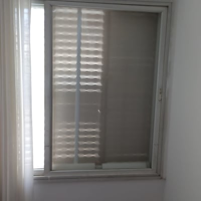 חלון זכוכית עם תריסים סגורים ווילון לבן