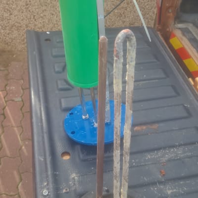 רכיבי דוד שמש על משטח, כולל גוף חימום ומיכל ירוק.