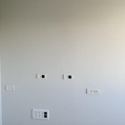 שקעים חשמליים מותקנים על קיר לבן במהלך שיפוץ