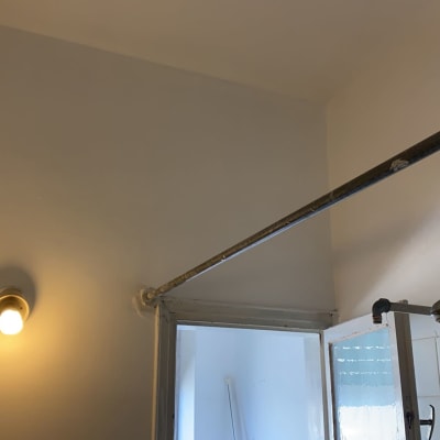 קיר צבוע בלבן עם מנורה דולקת