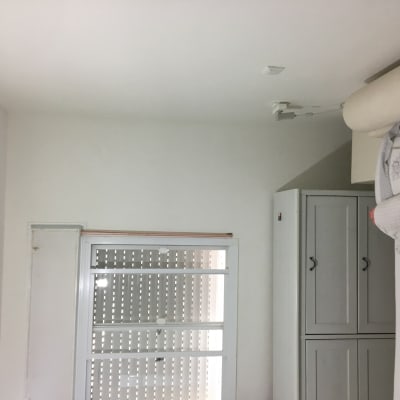 חלון עם תריסים סגורים ותקרה לבנה