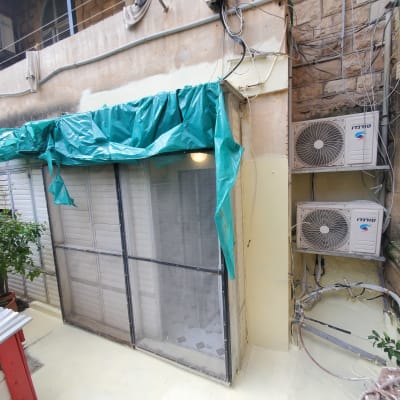 כיסוי פלסטיק ירוק על חלון לאיטום מפני גשם