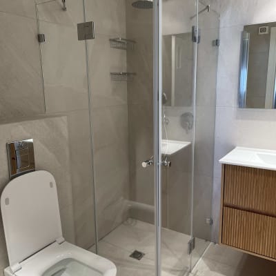 מקלחון זכוכית עם ראש מקלחת, שירותים וכיור